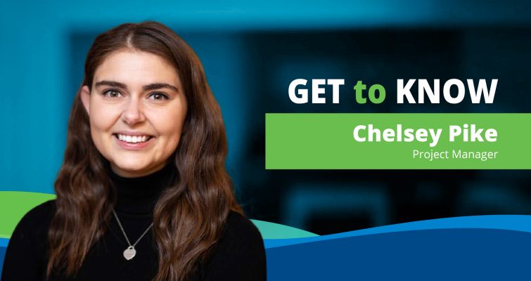 Portrait of a woman with long brown hair wearing a black top, set against a blue background with the text 'GET to KNOW Chelsey Pike, Project Manager'. The image is framed with green and blue accents.